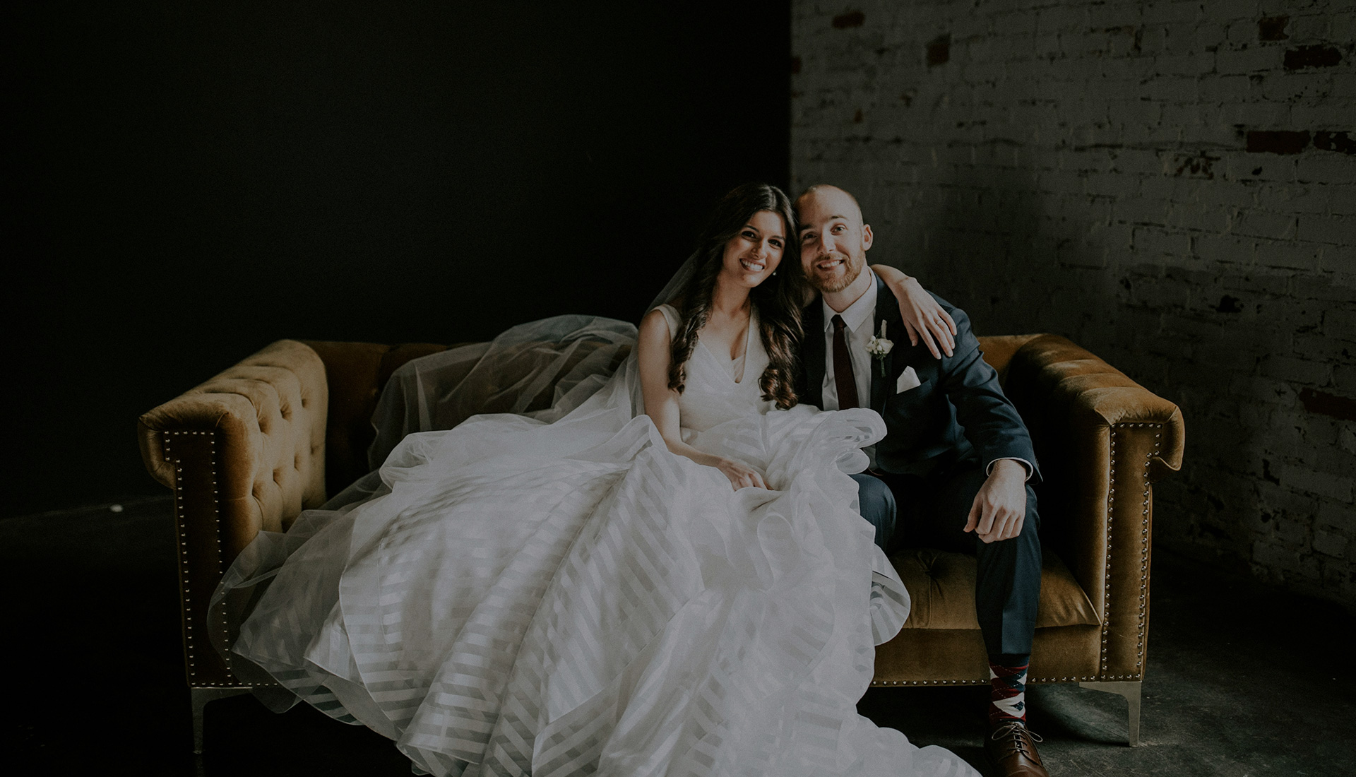 Bridal couple on couch smiling | TheHawthornNH