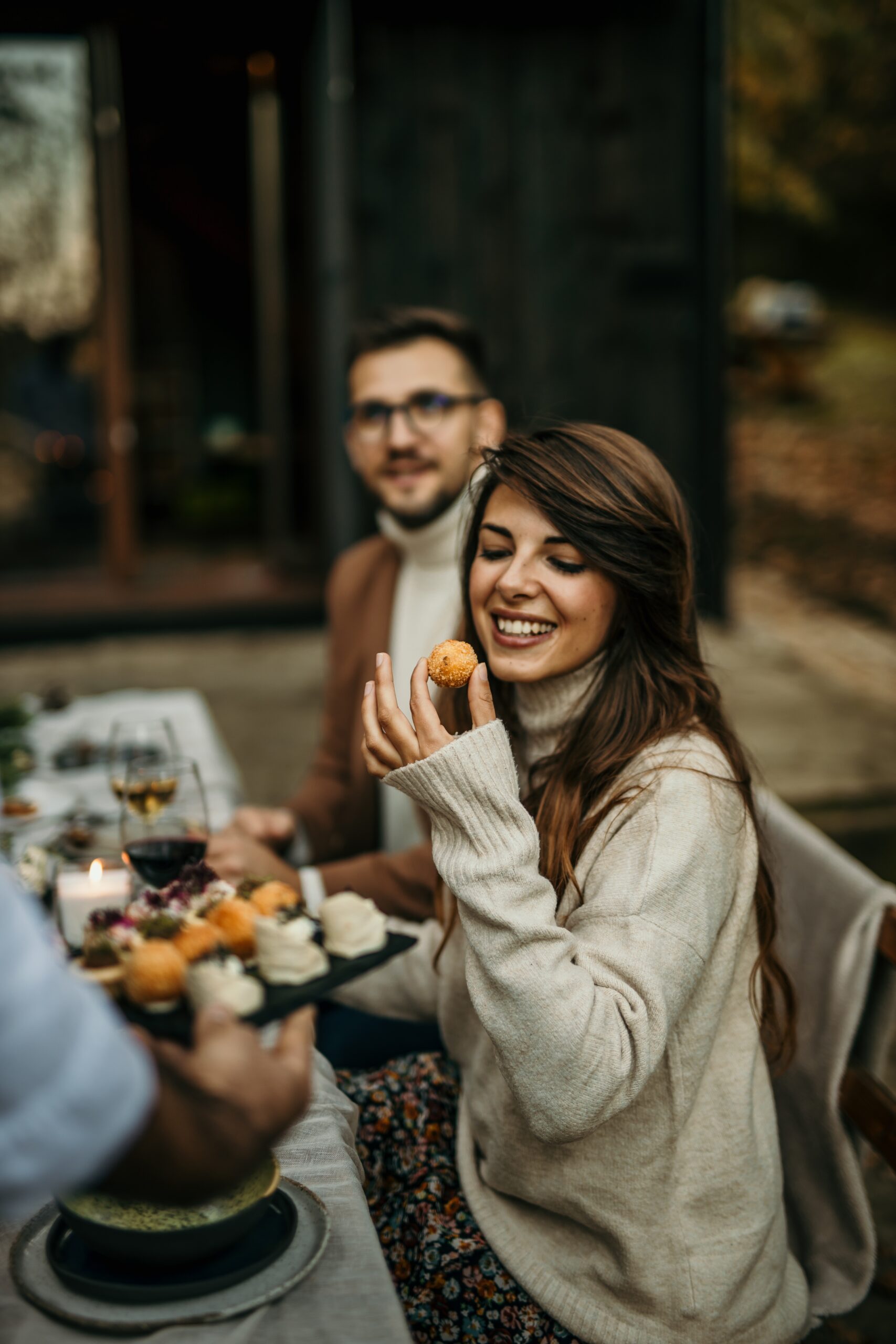 a woman tastes food at an event with friends and family