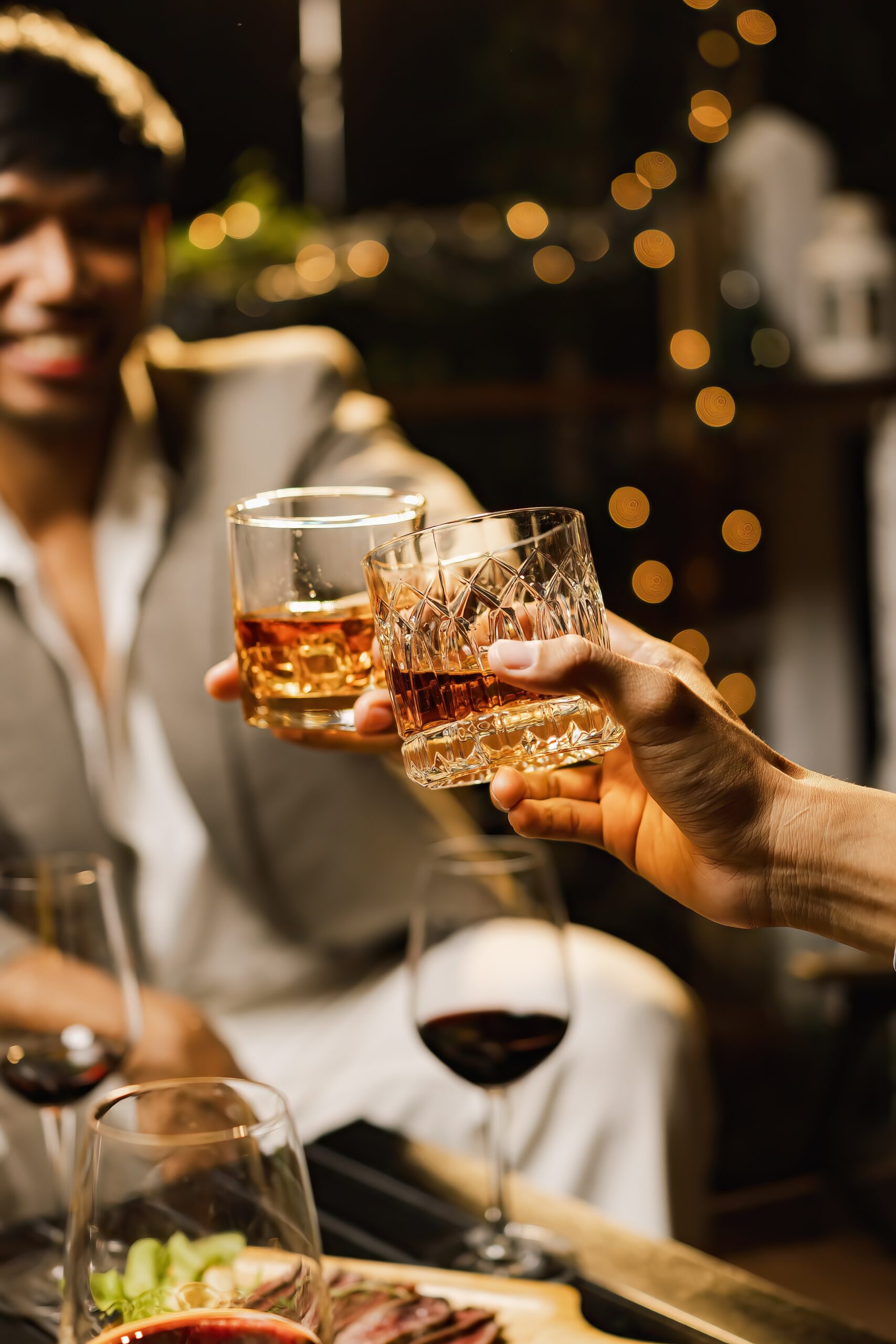 two men share drinks with others at an event