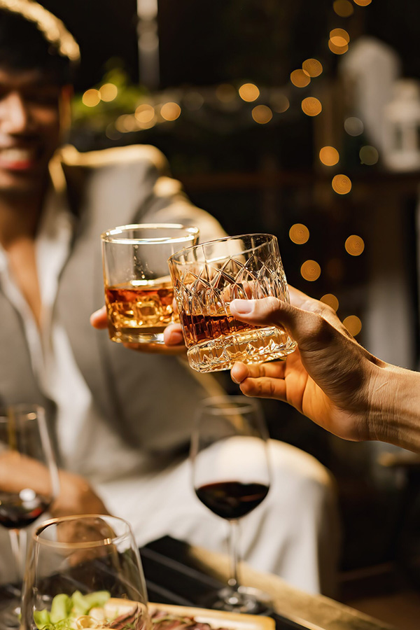 two men share drinks with others at an event