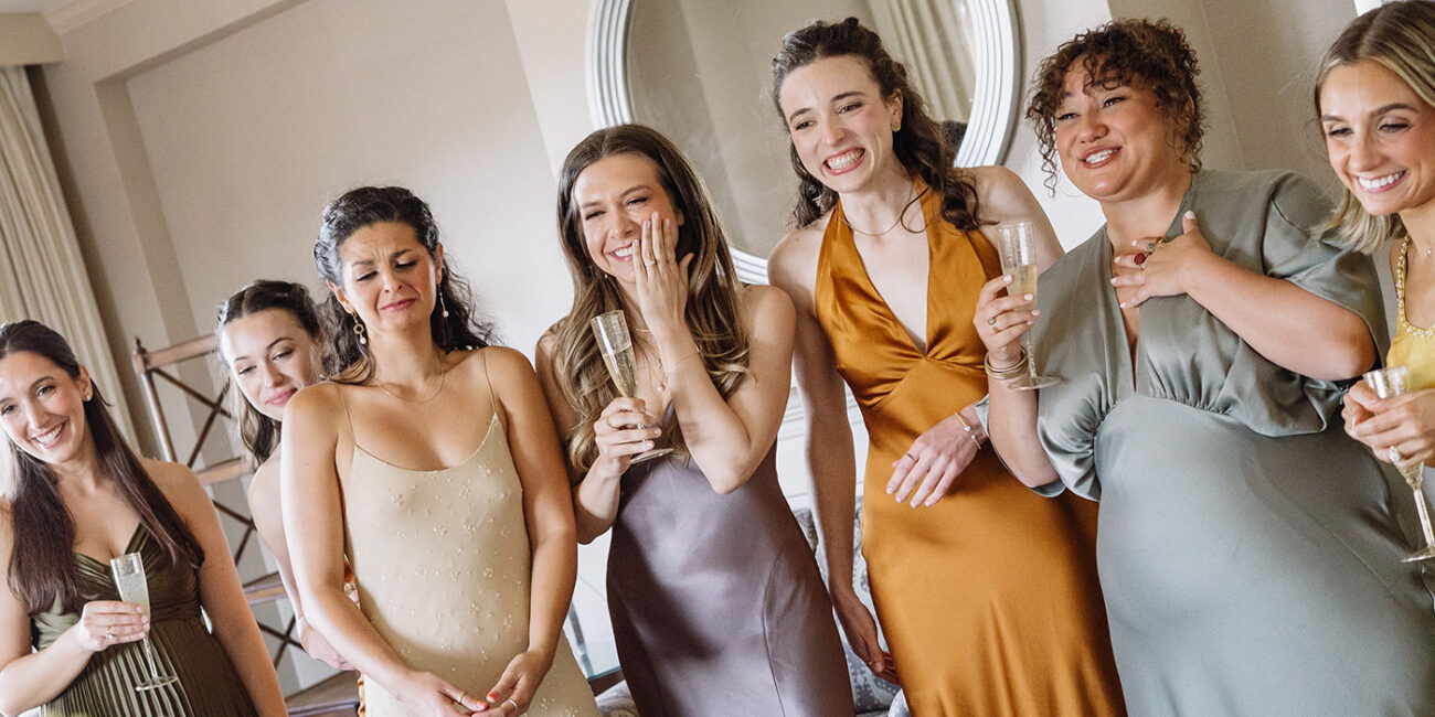 Excited bridesmaids looking at bride