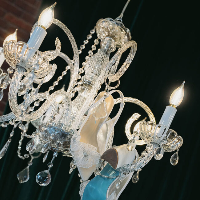 High heel hanging from elegant chandelier