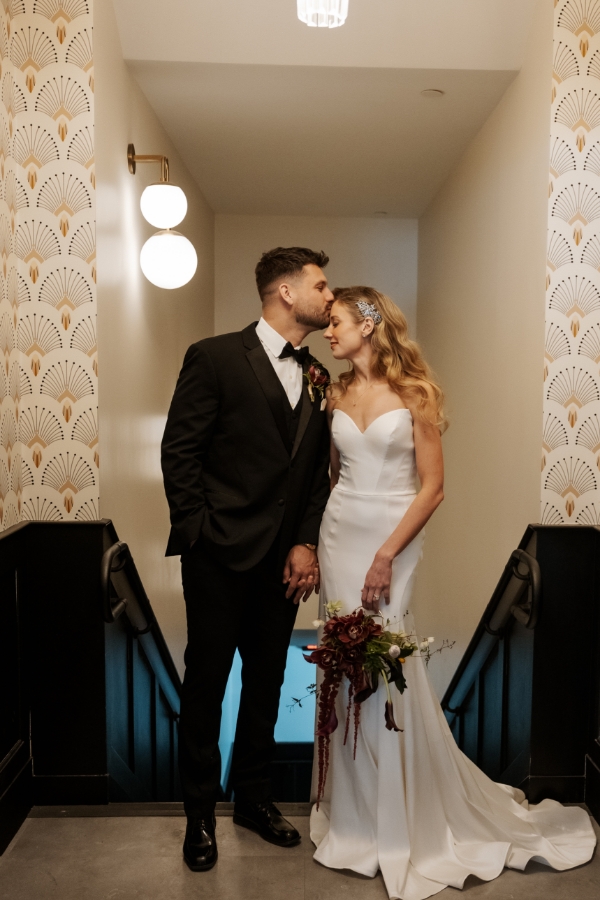 Bride and groom sharing a sweet moment in the hallway