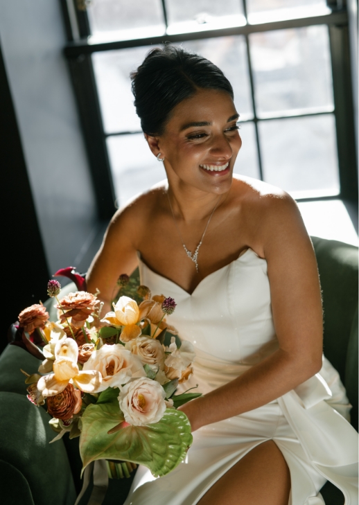 Bride posing with floral arrangement