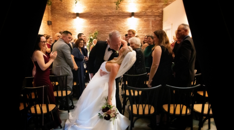 Groom dipping bride for a kiss down the aisle