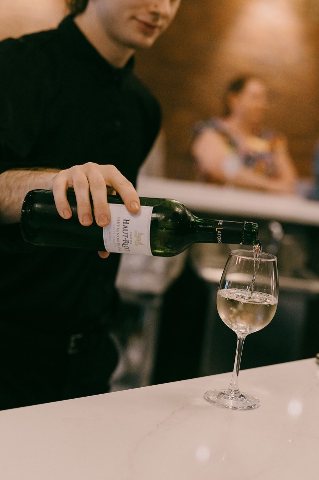Bartender pouring a glass of white wine