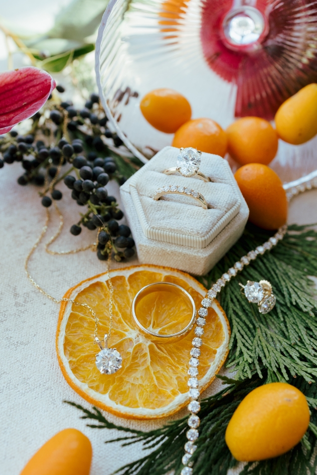 Engagement detail shot of rings with flowers and citrus
