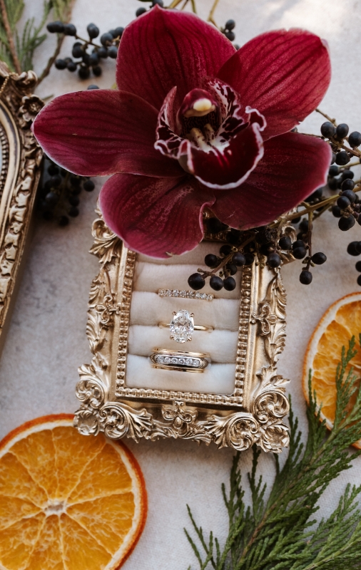 Engagement detail shot of rings with flowers and citrus