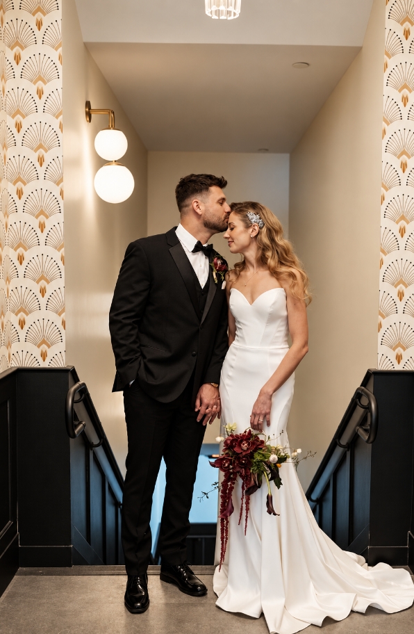 Bride and groom sharing a sweet moment in the hallway